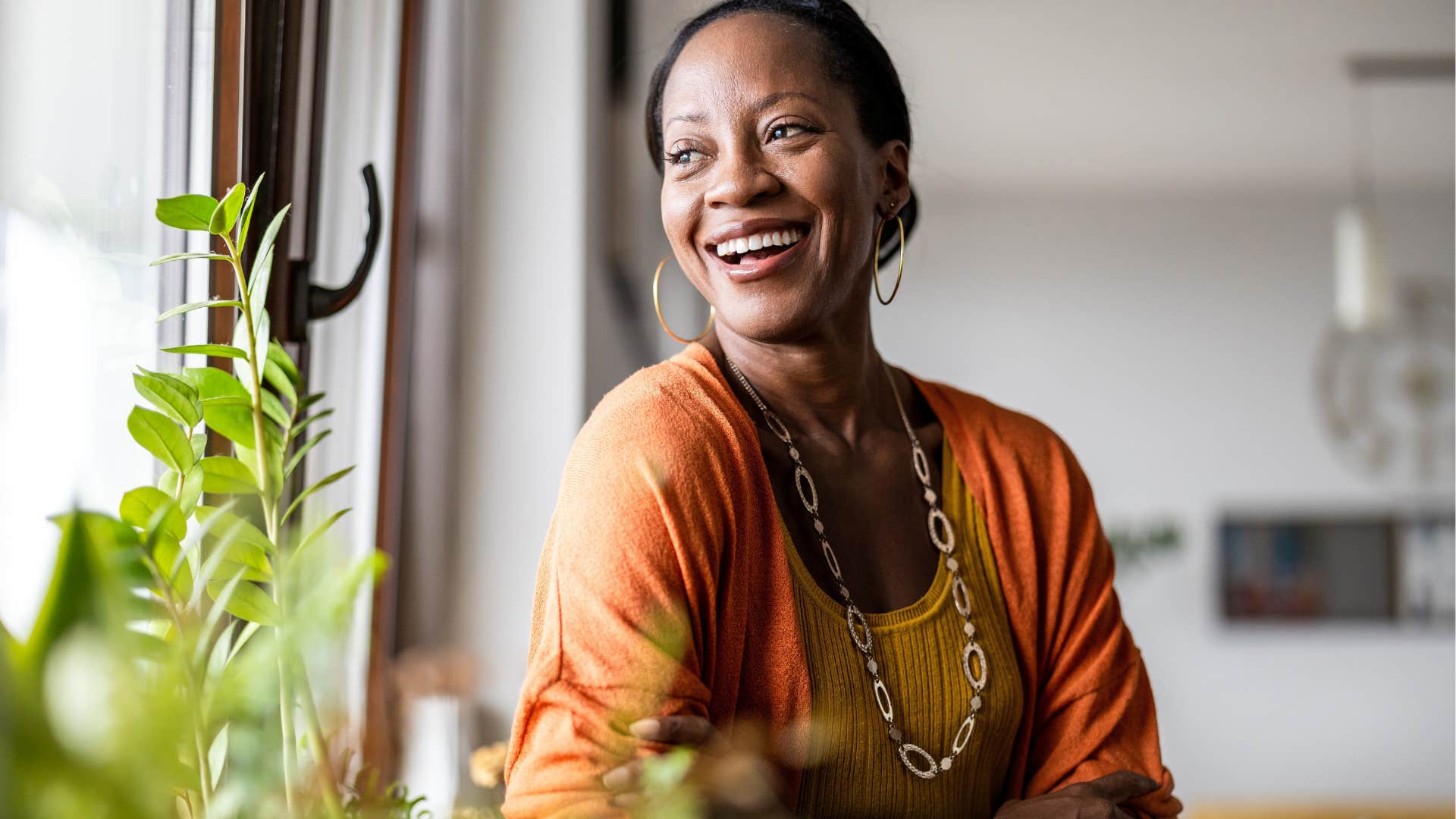 Woman smiling and looking out a window.