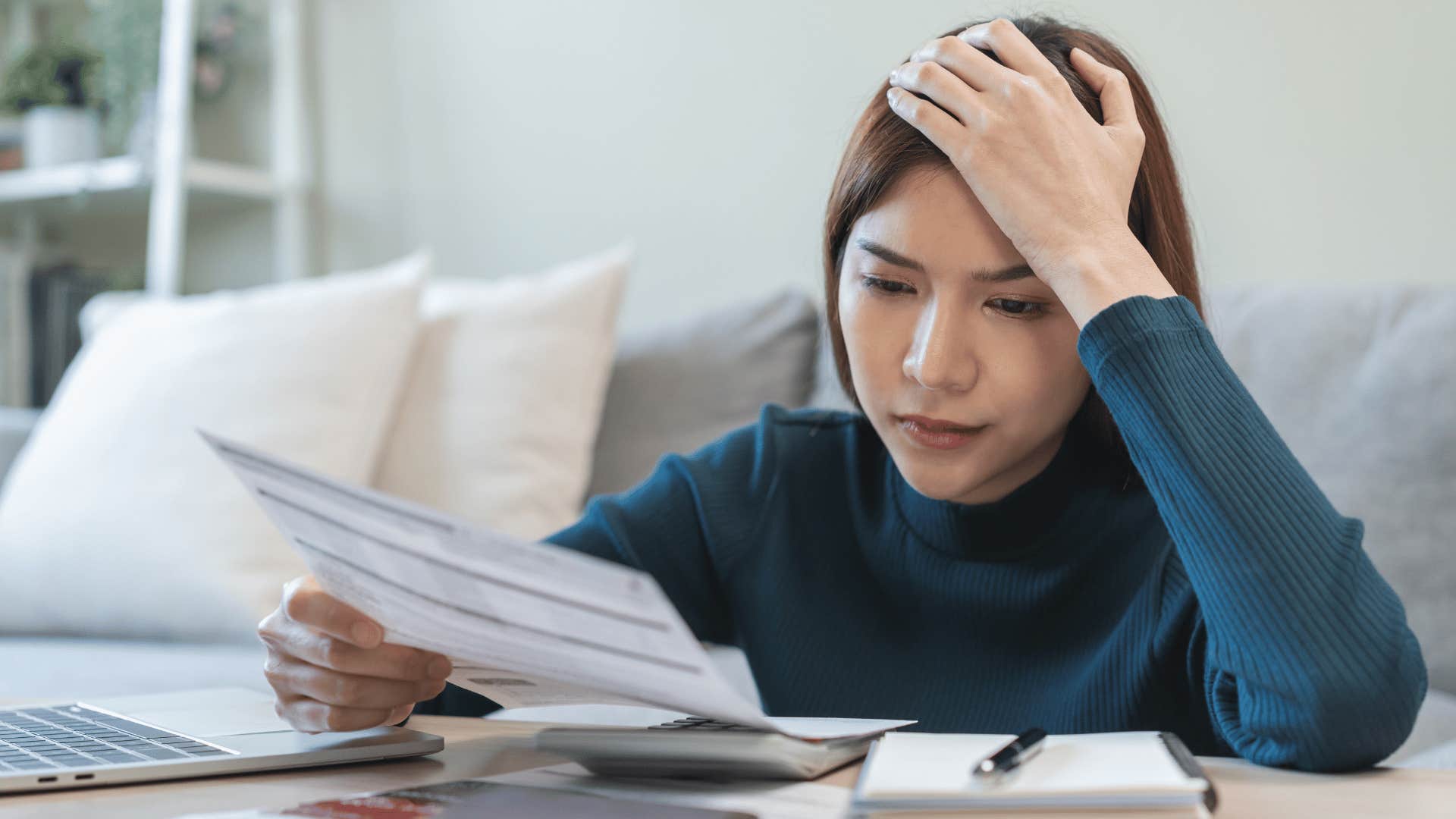 upset woman looking at bills