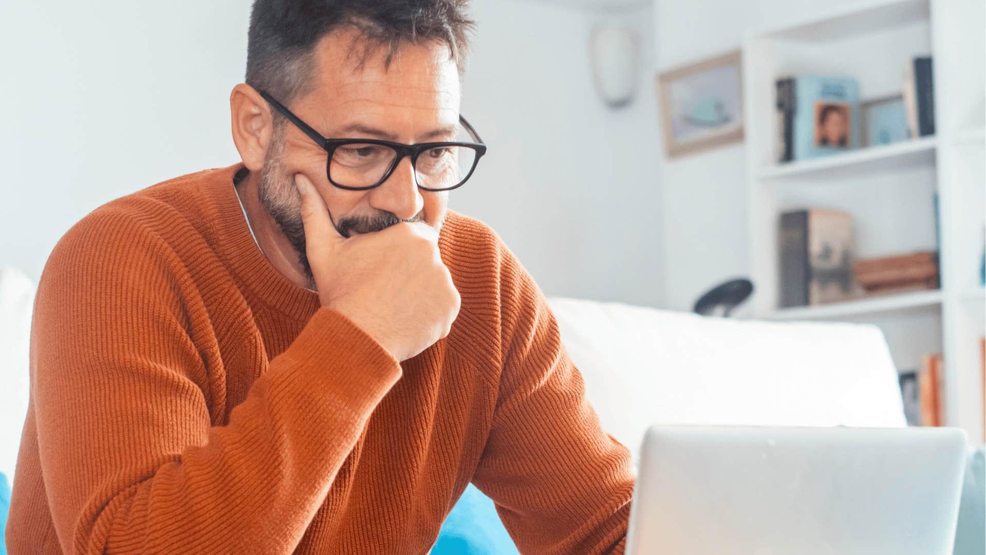 man sitting on couch with laptop