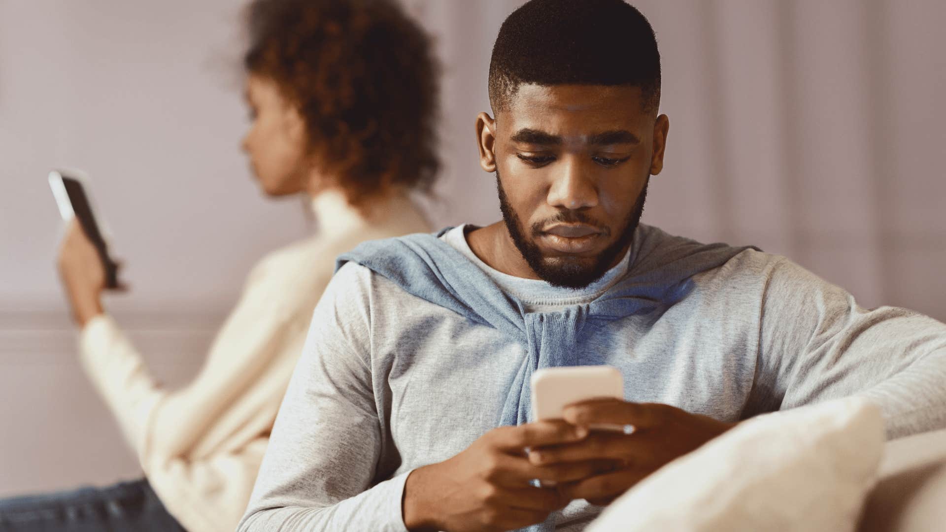 couple on couch on their phones