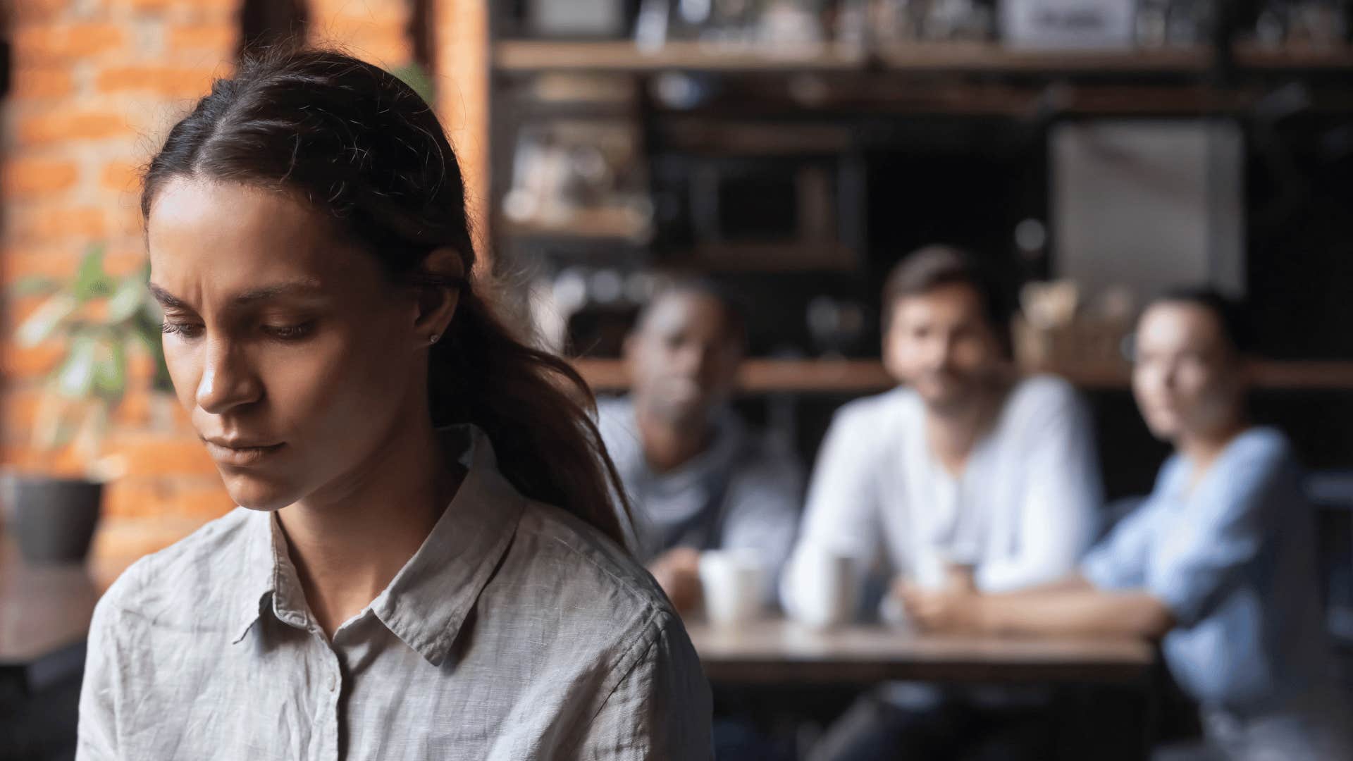 woman sitting alone with people behind her