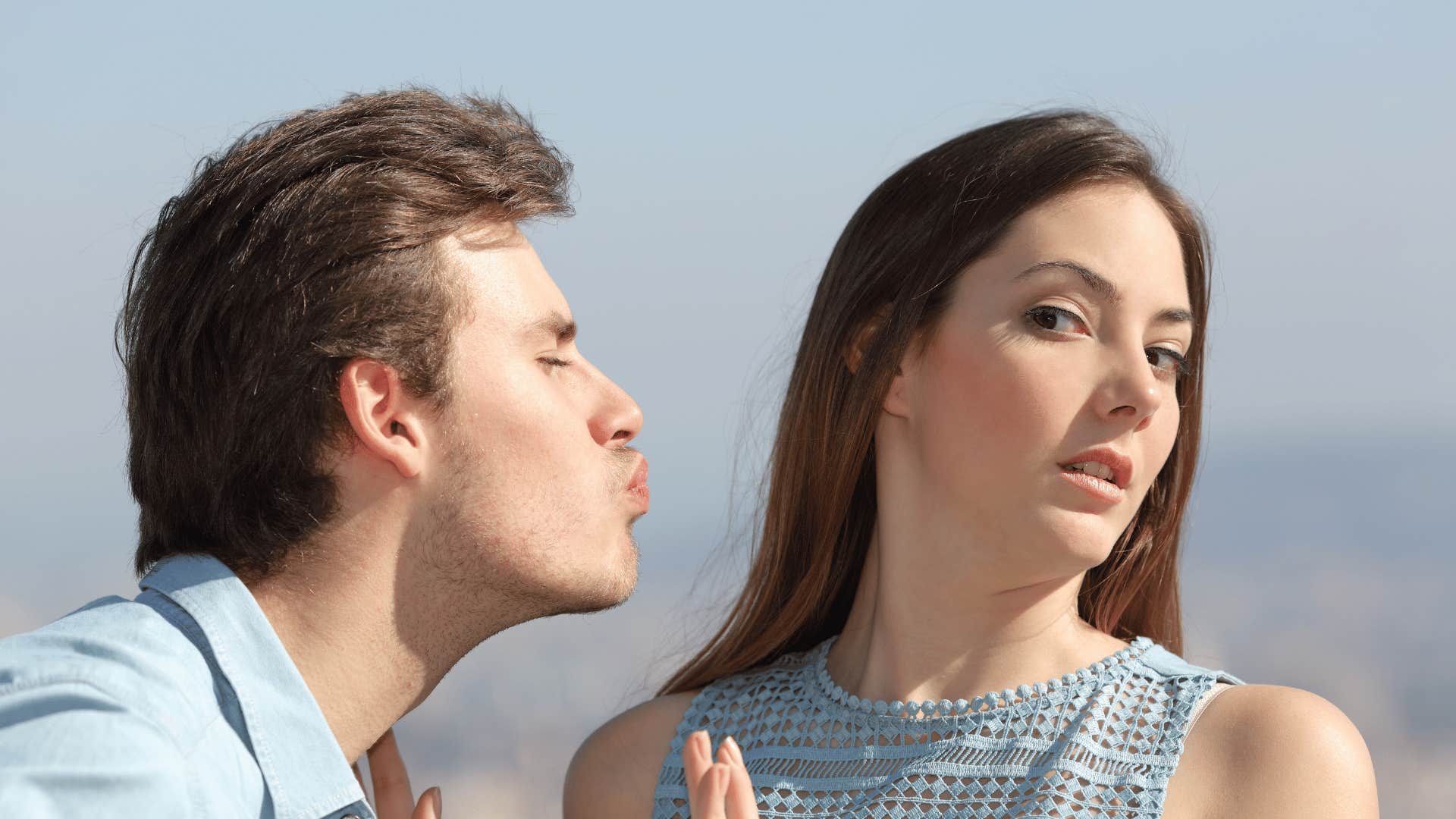 woman avoiding kiss from man