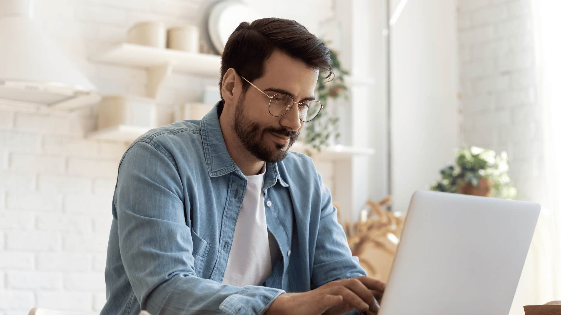 man typing on laptop