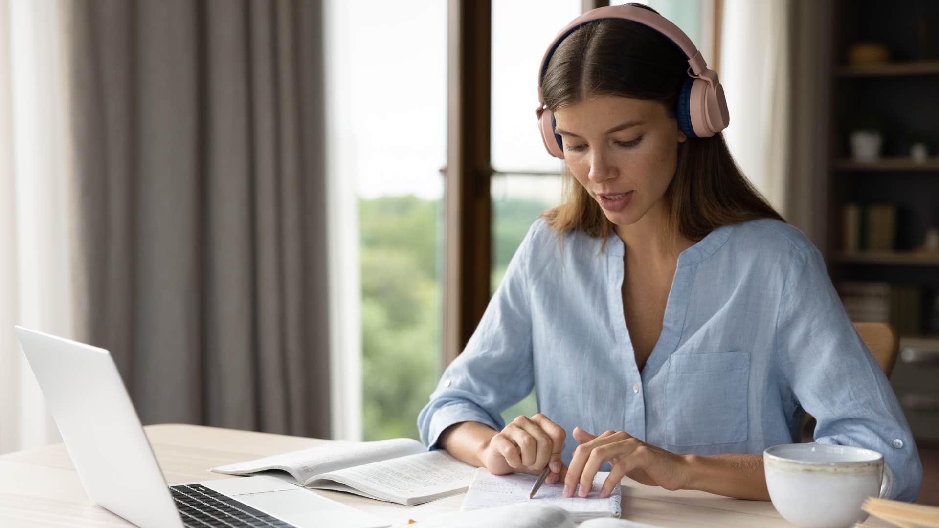 Focused engaged student girl in big headphones studying foreign language