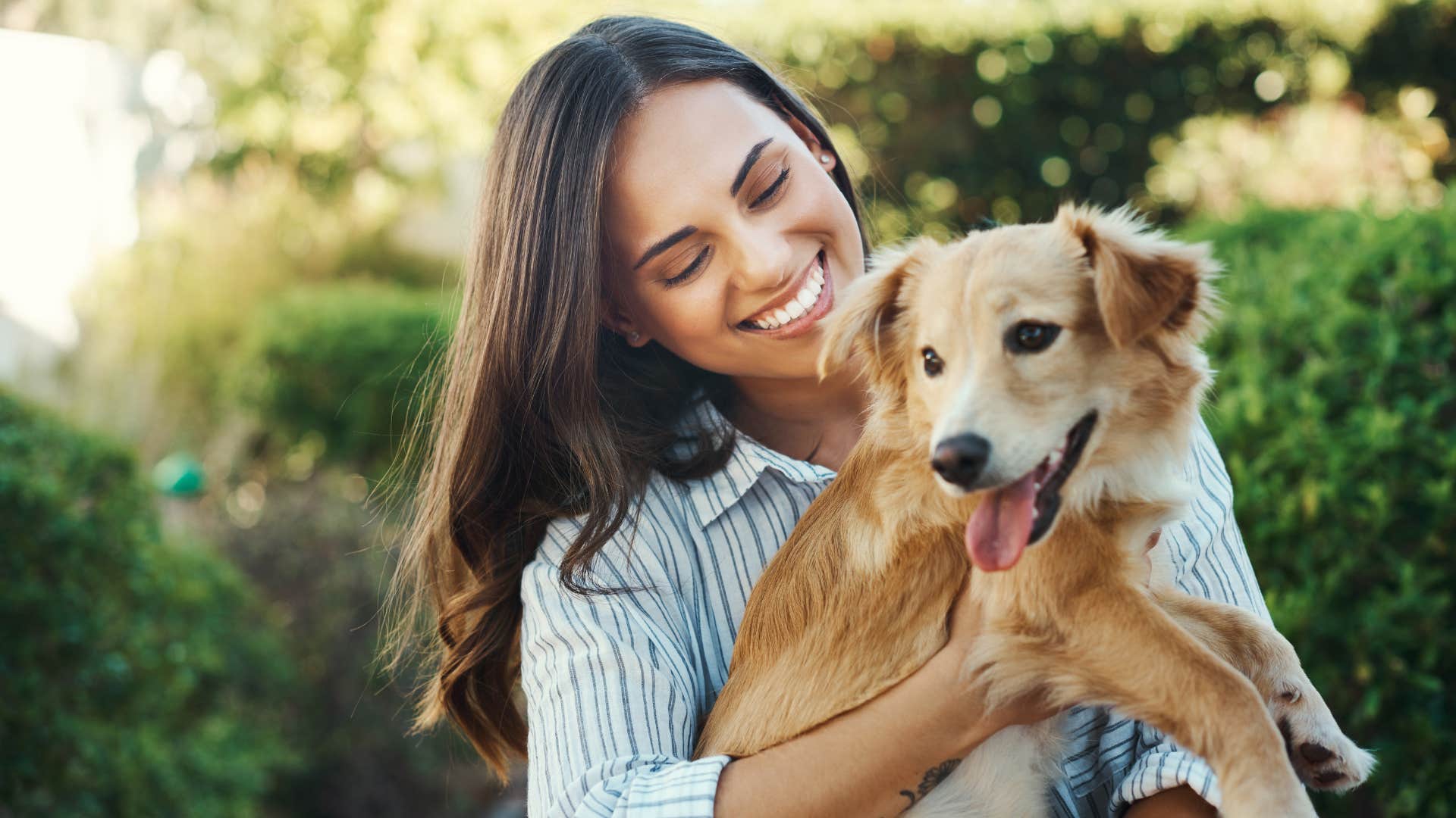 Woman smiling and holding her dog