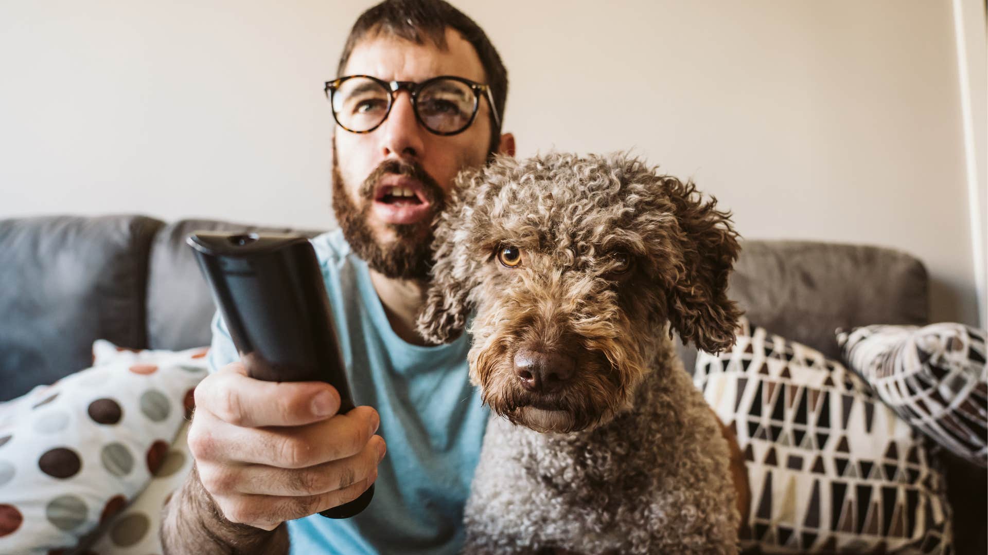 Man watching T.V. with his dog on his lap