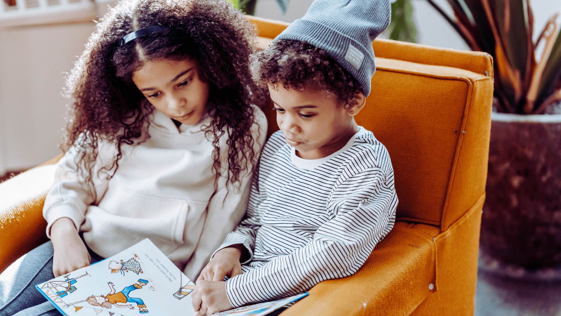 brother and sister reading a book