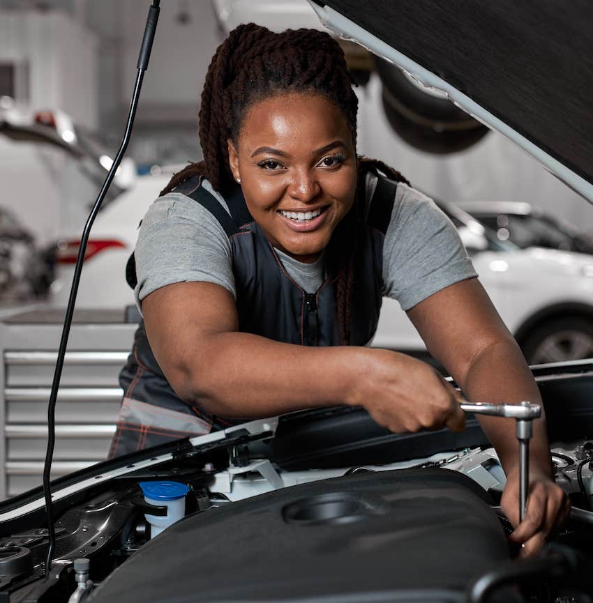 Woman wokring on engine of car