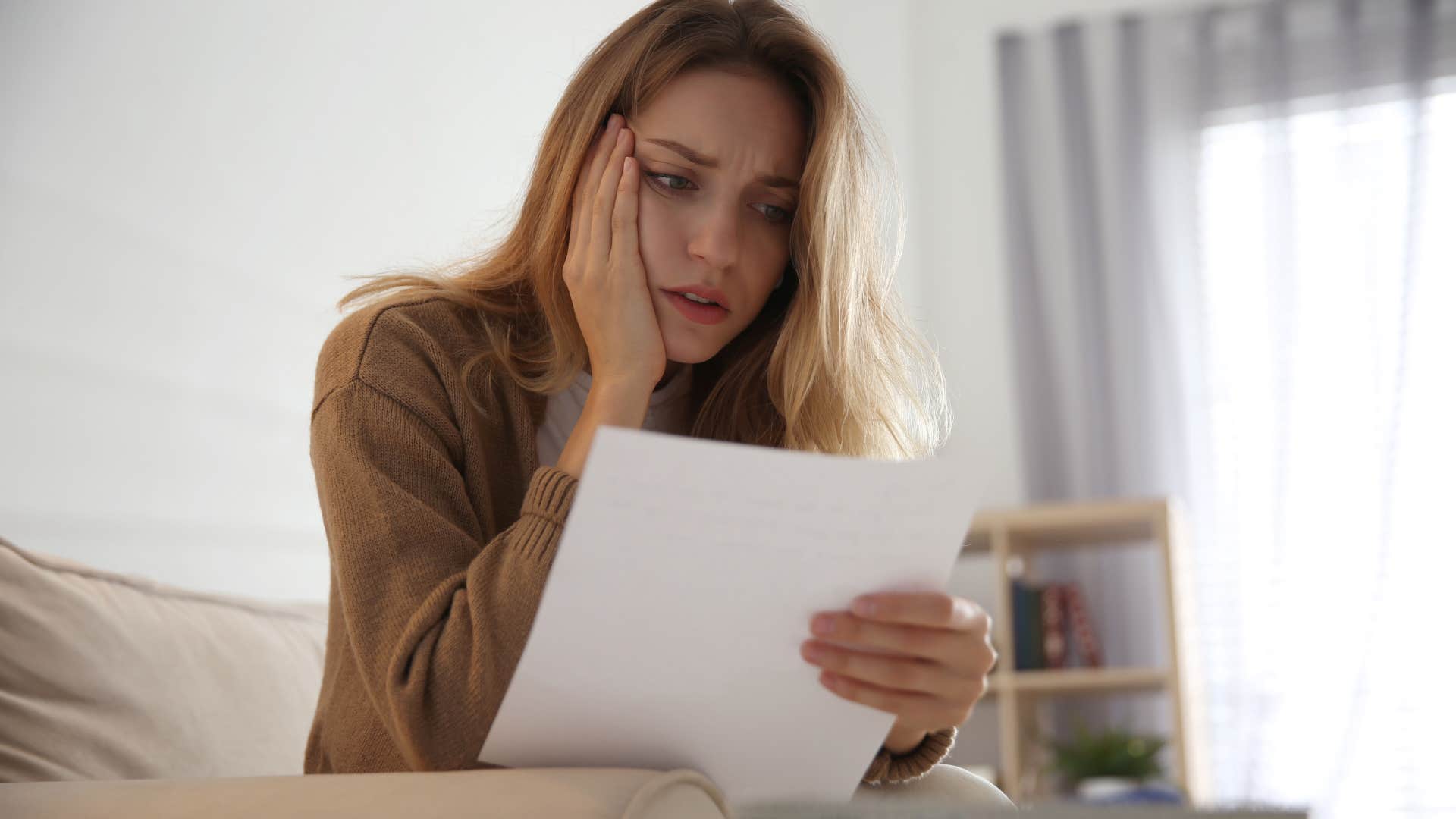 concerned chronically single woman looking at bill