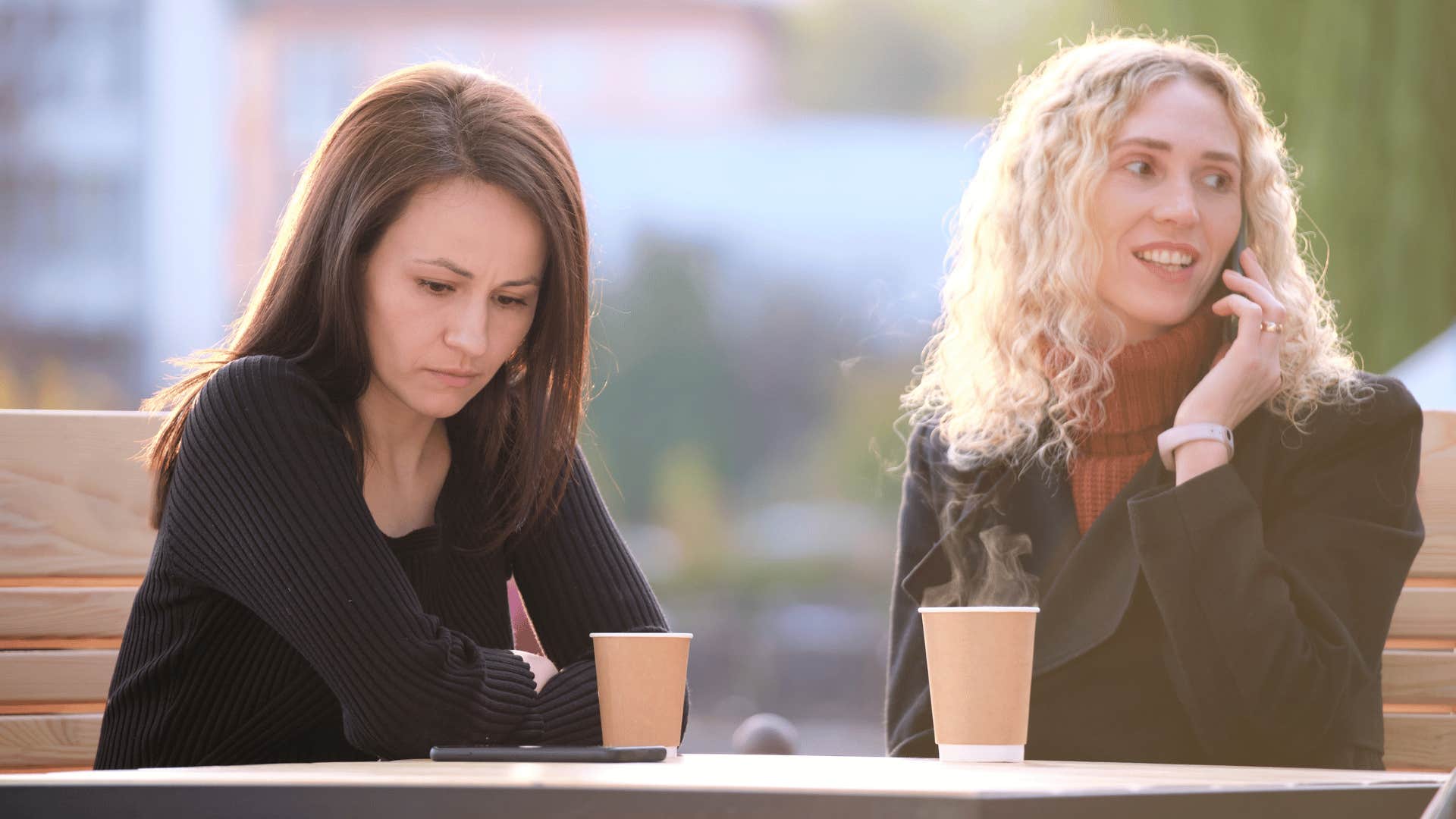 woman ignoring friend while chatting on the phone