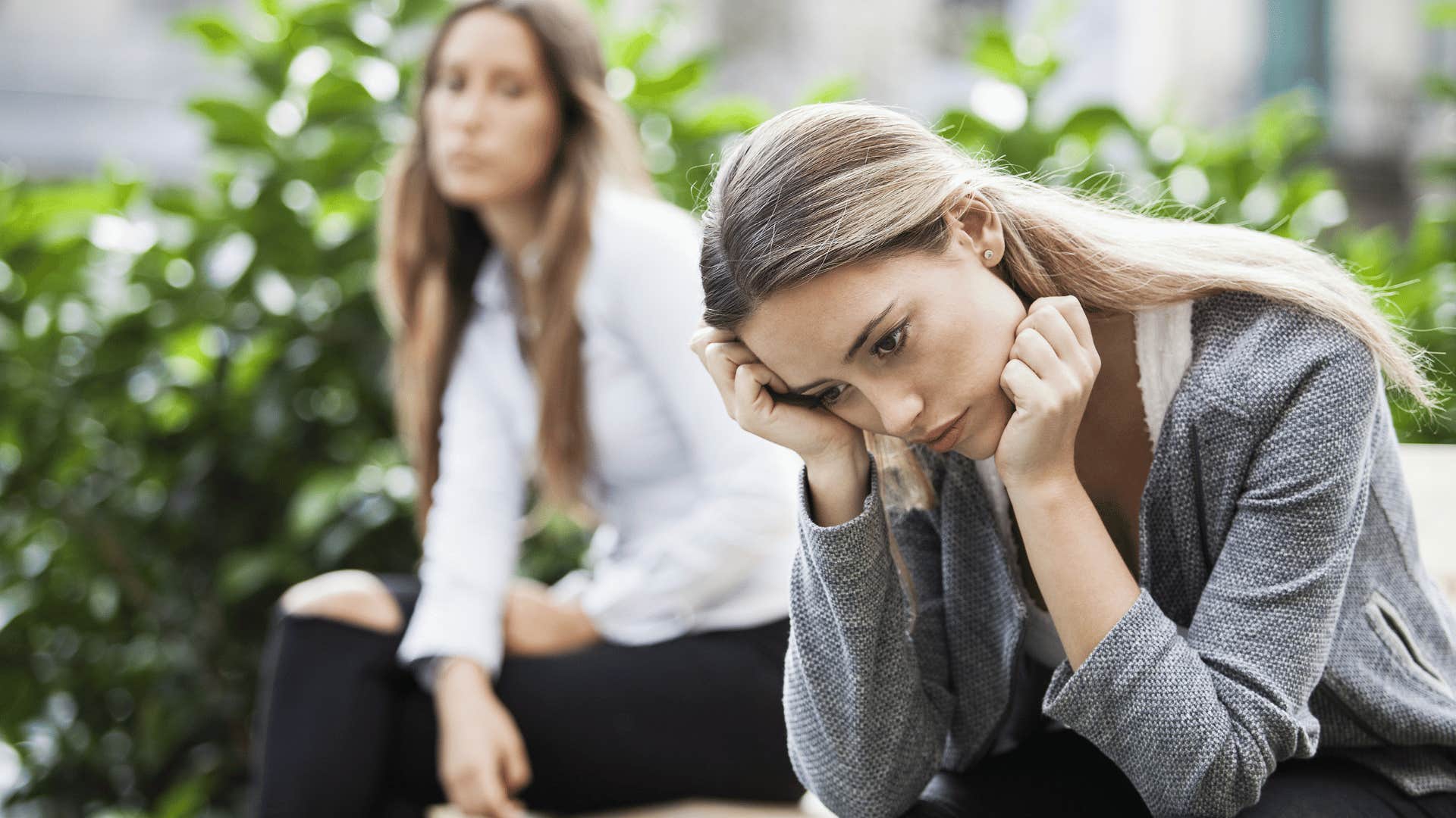 woman looking upset while friend looks at her