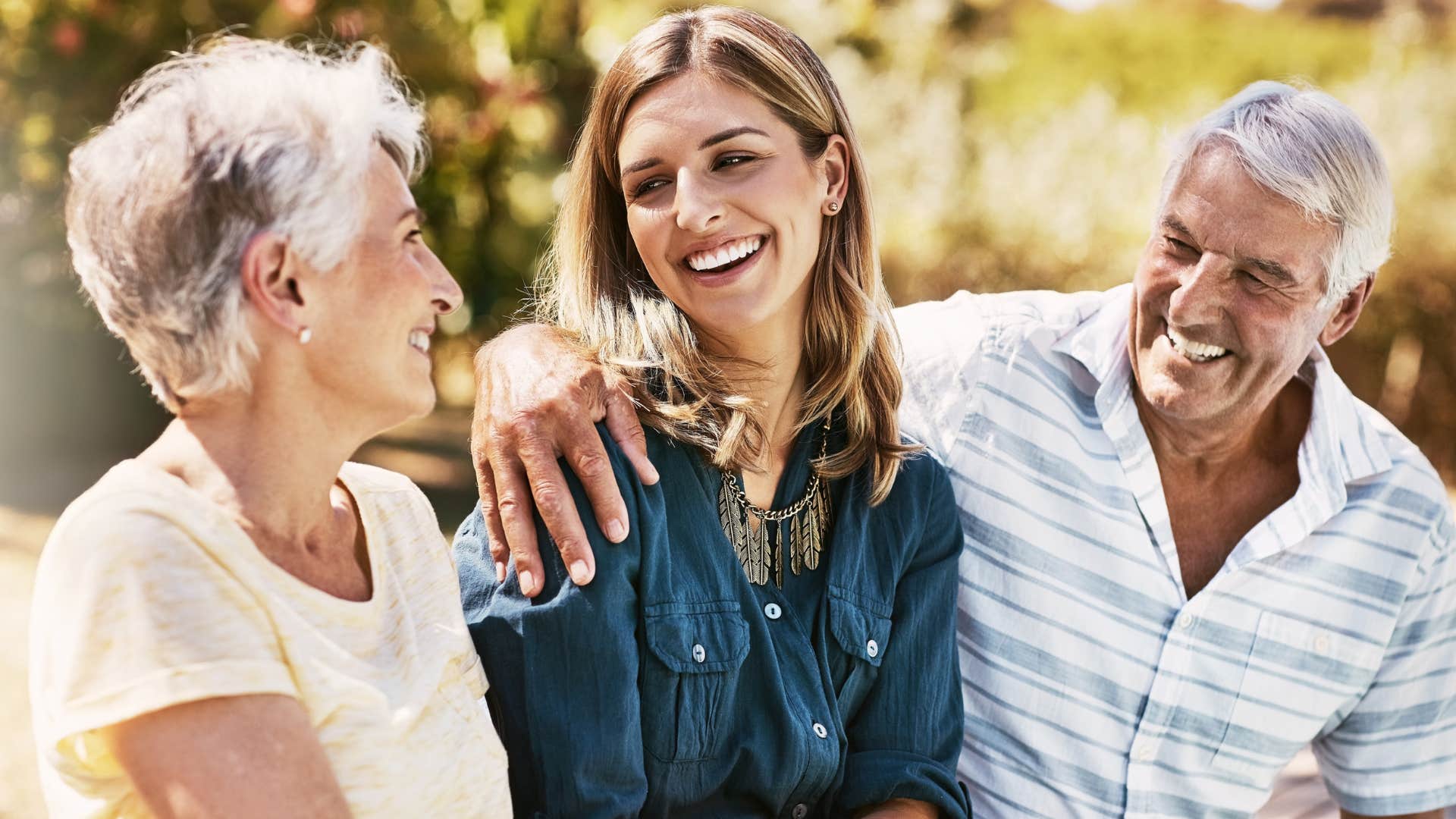 Woman smiling and talking to her older parents.