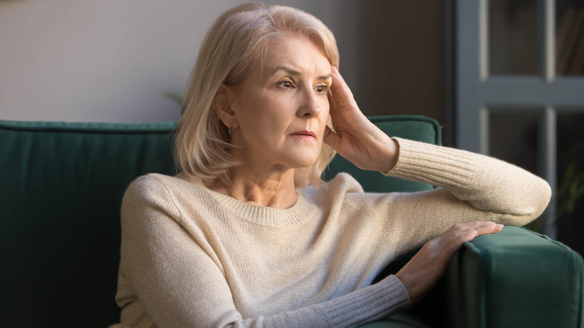 Woman looking anxious staring out a window.