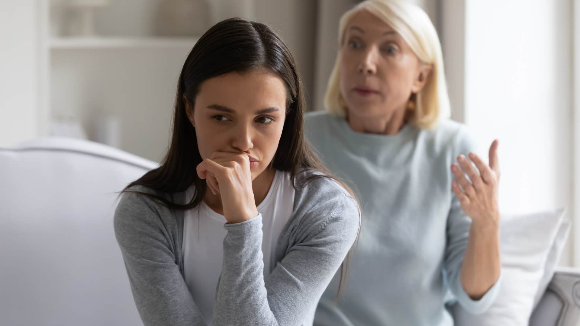 Upset woman turned away from her mother.