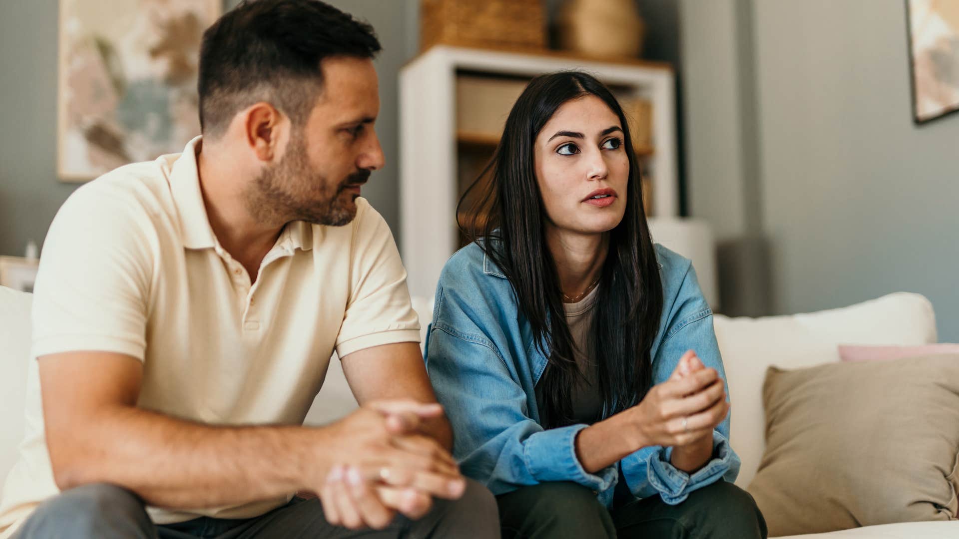 Upset couple sitting together on a couch