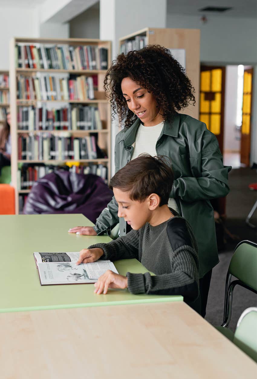 Teacher helping student in the library after class