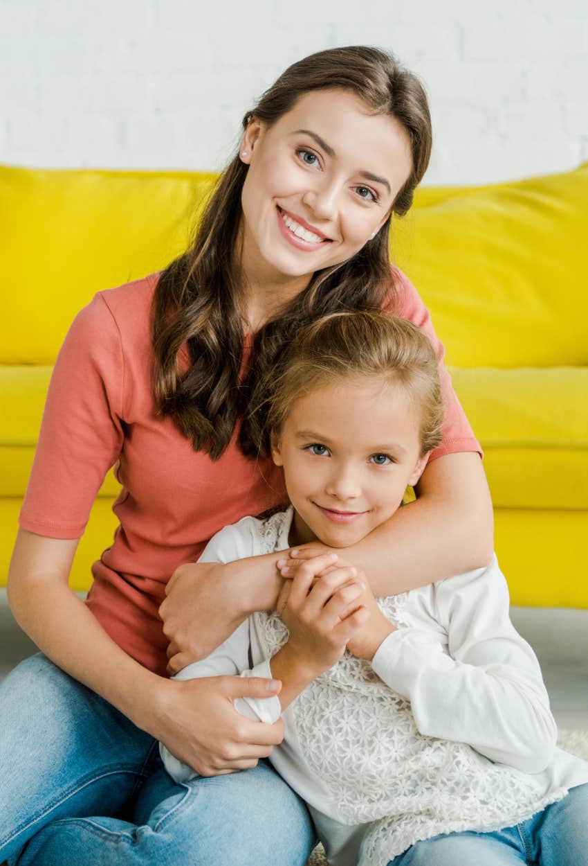 teen babysitter hugging little girl