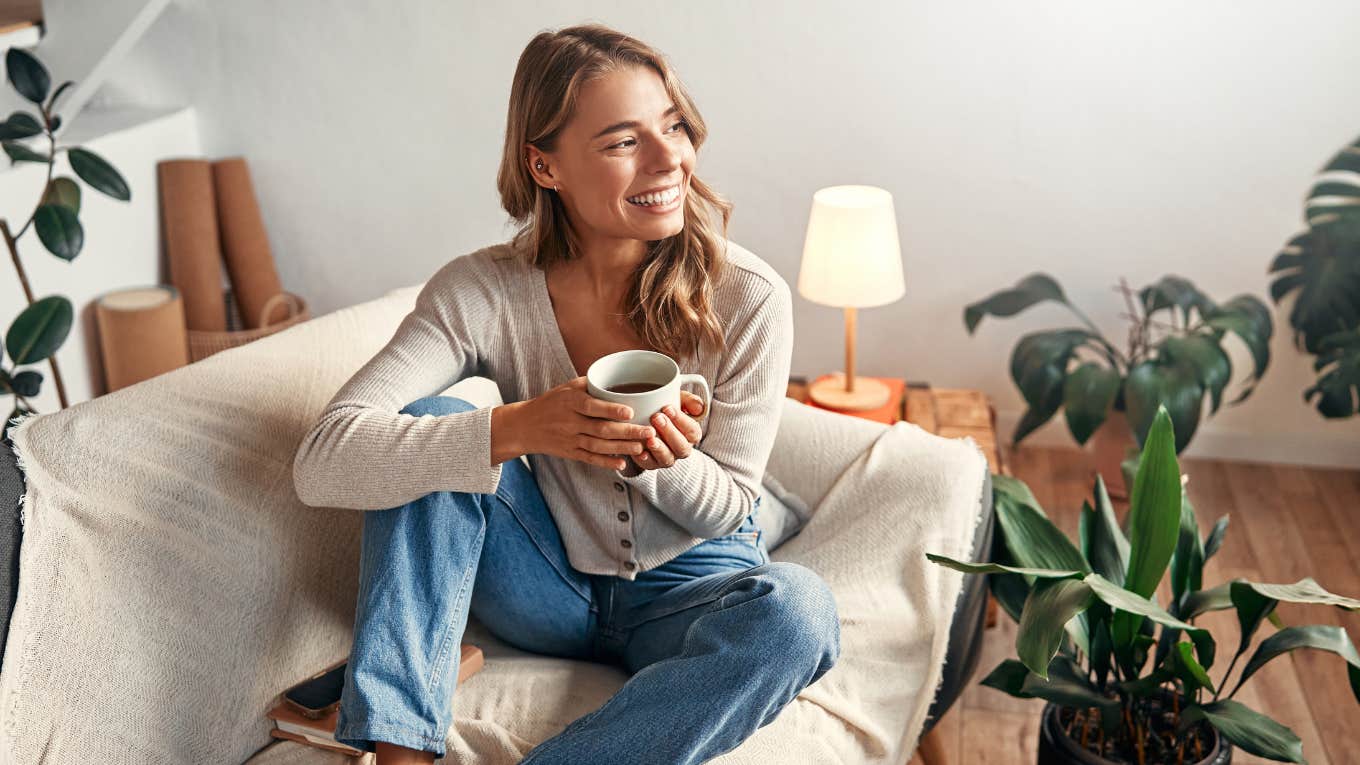 woman smiling holding a morning cup of coffee