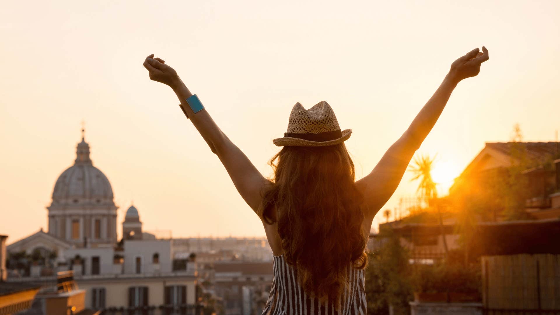 woman looking at city with hands up