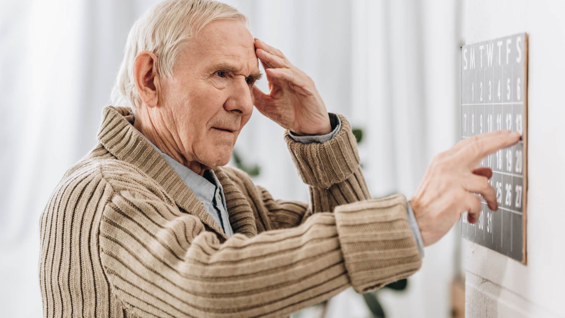 boomer man looking at wall calendar