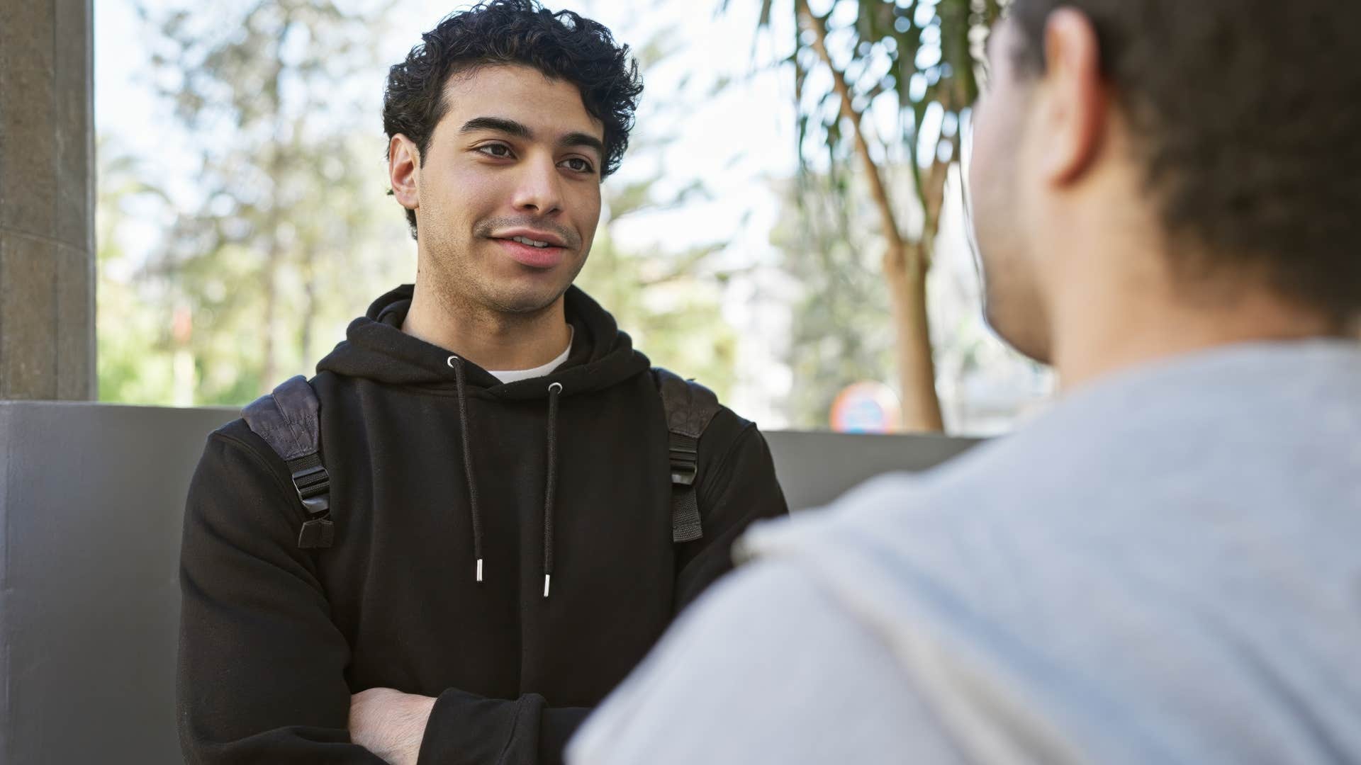 Smiling young man talking to his friend. 