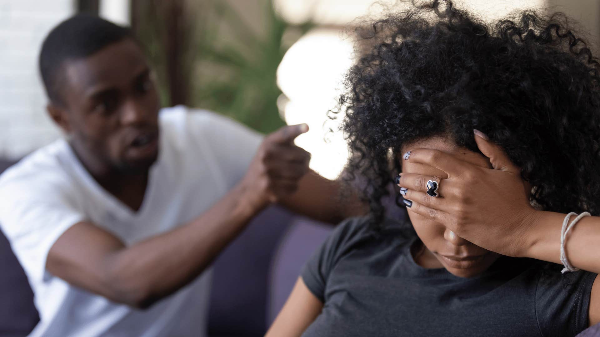 man yelling and pointing finger at woman