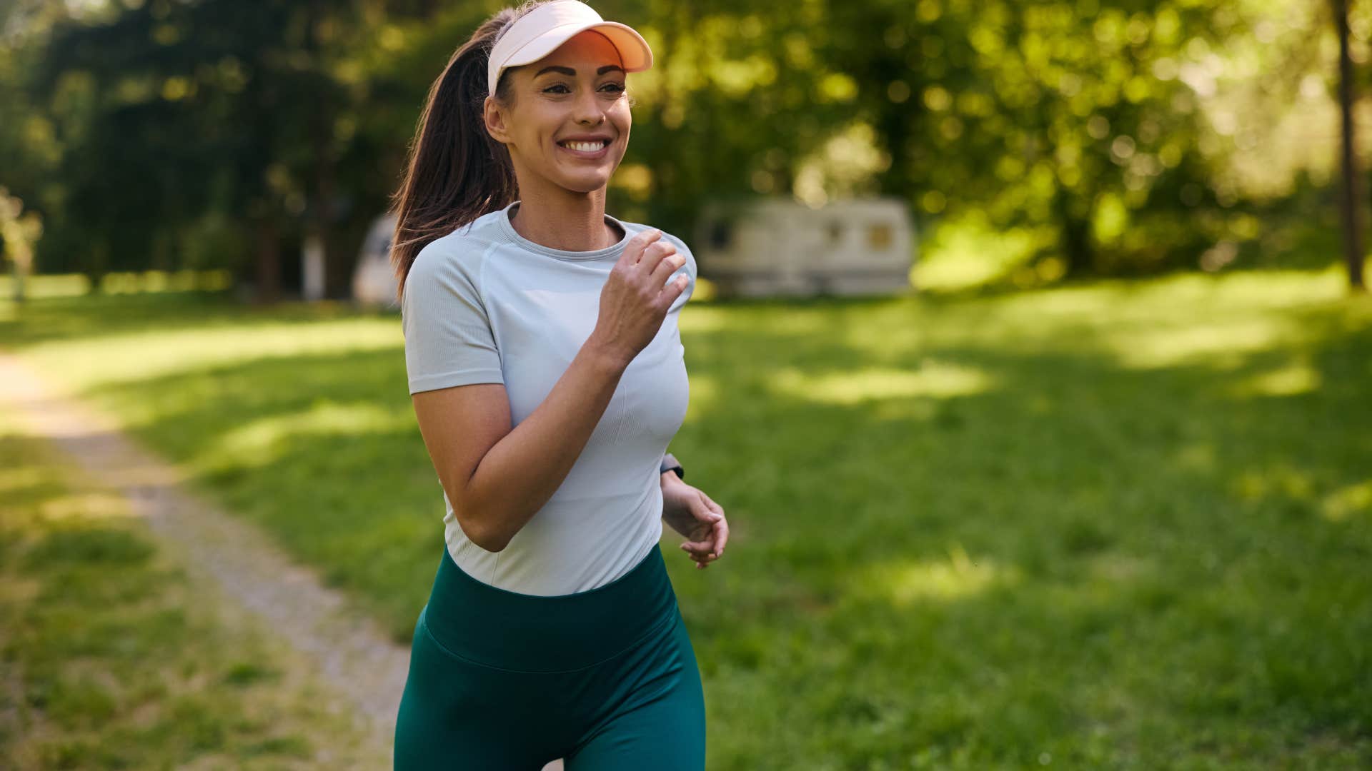 Happy athletic woman running while exercising in nature