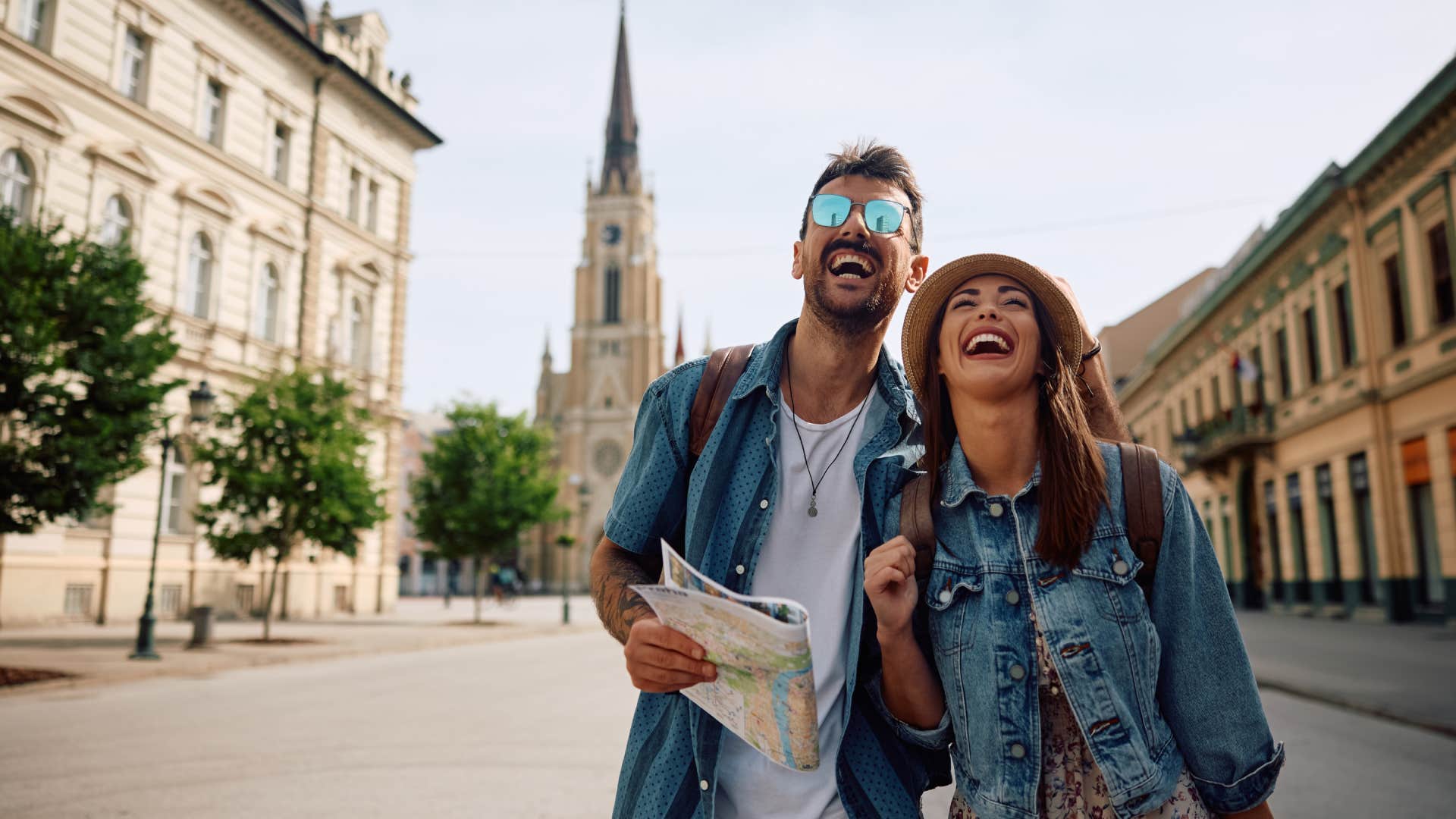 Young couple of travelers laughing and having fun while walking in the city.