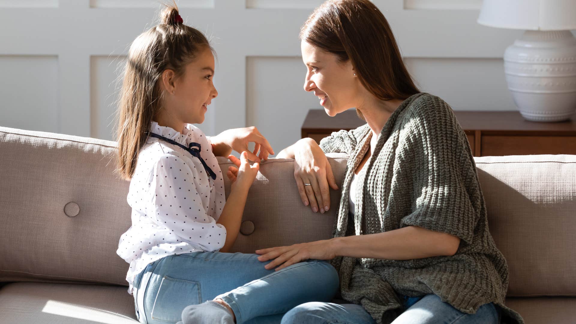 Woman talking to her daughter on the couch.