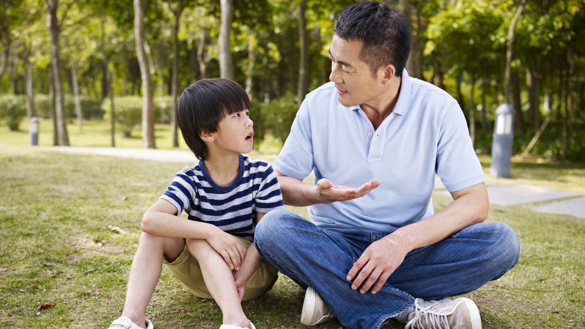 Father talking to his young son outside.