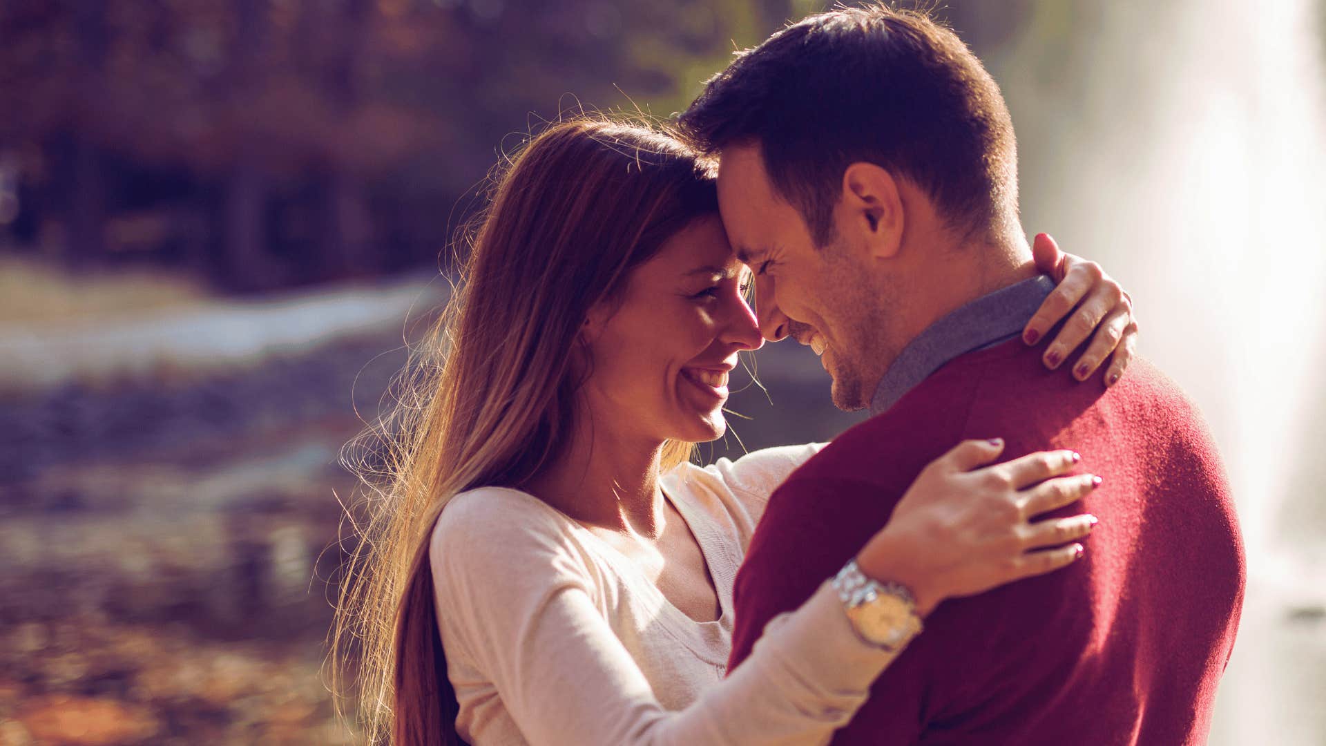 husband and wife hugging in nature