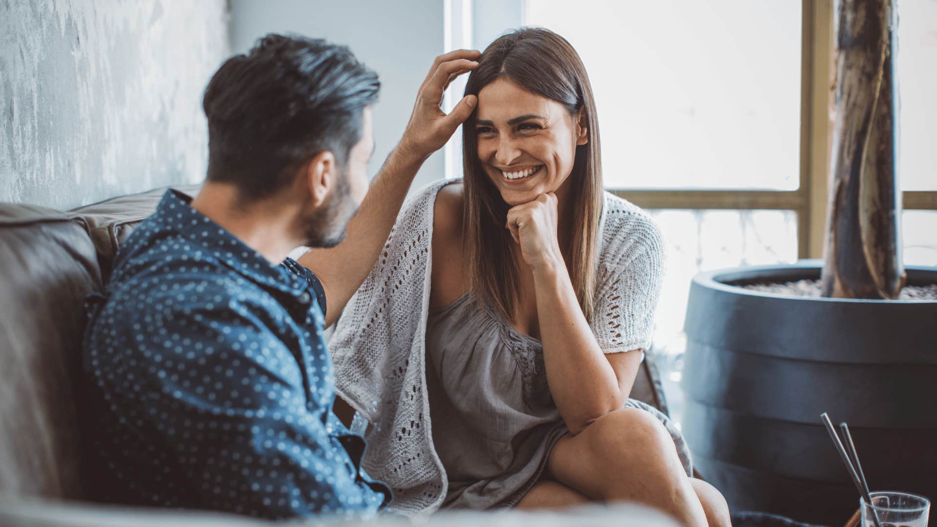 man listening to wife as they talk on the couch