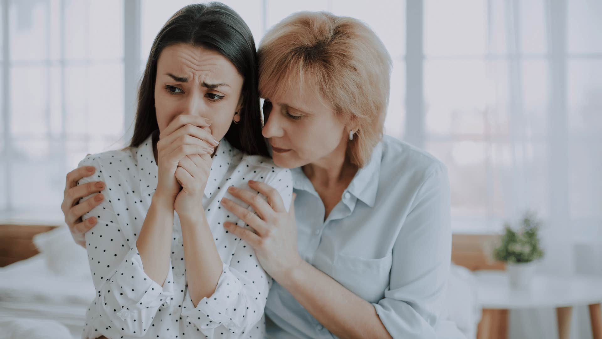 mother comforting upset daughter