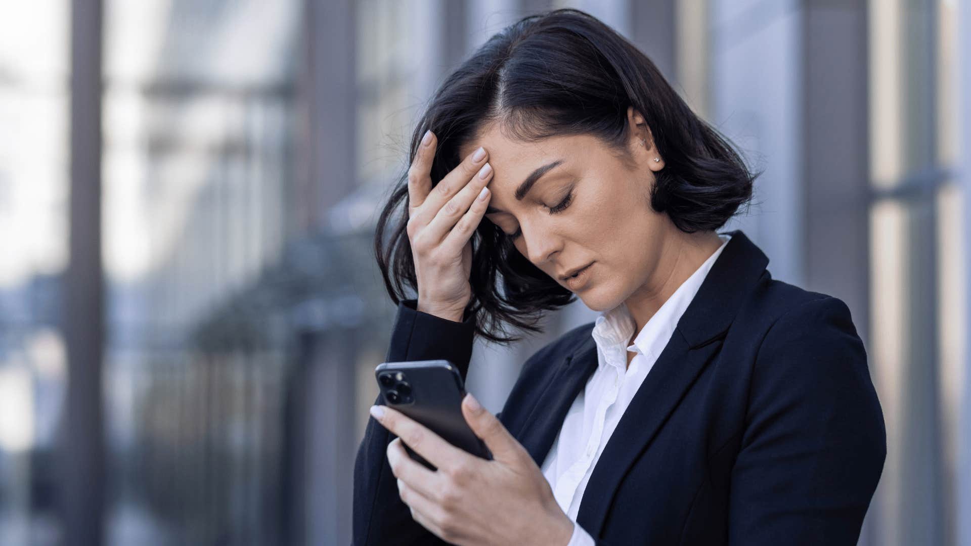 woman stressed while staring at phone