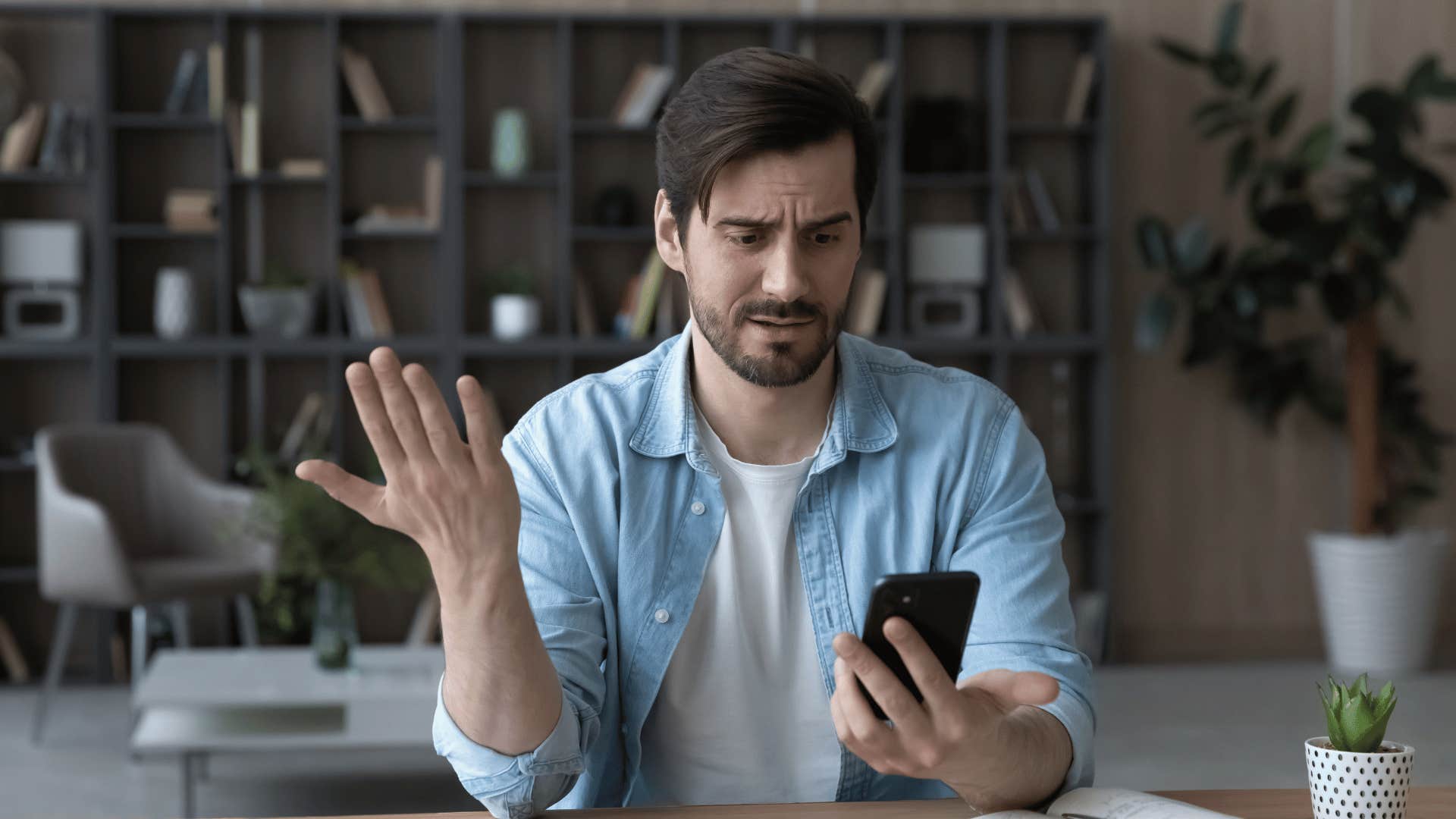 man staring at phone in disbelief