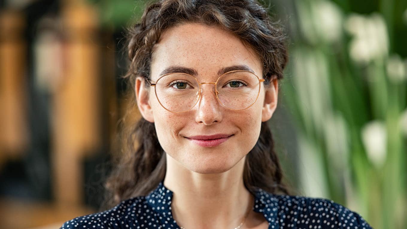 smiling woman with glasses wearing a polka dot shirt