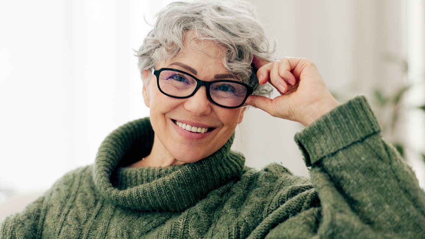 Older woman with glasses smiling confidently