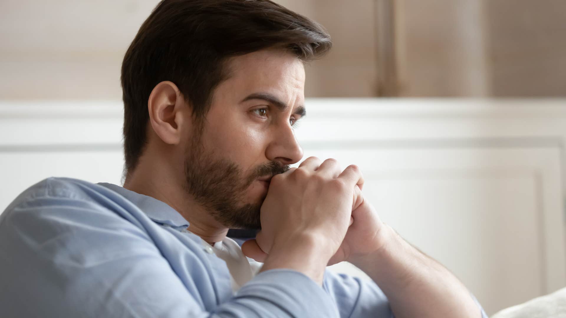 Man looking sad holding his head in his hands.