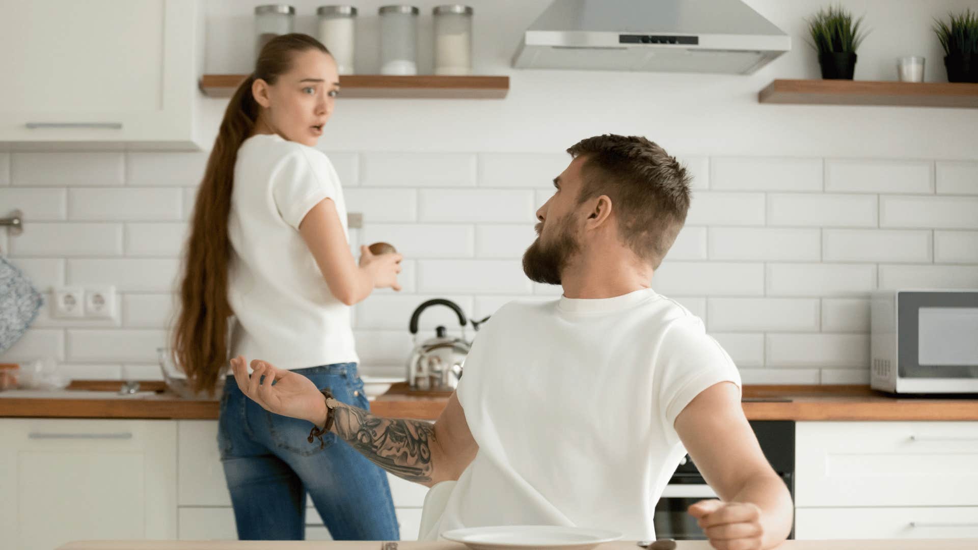 man yelling at woman while she tries to cook