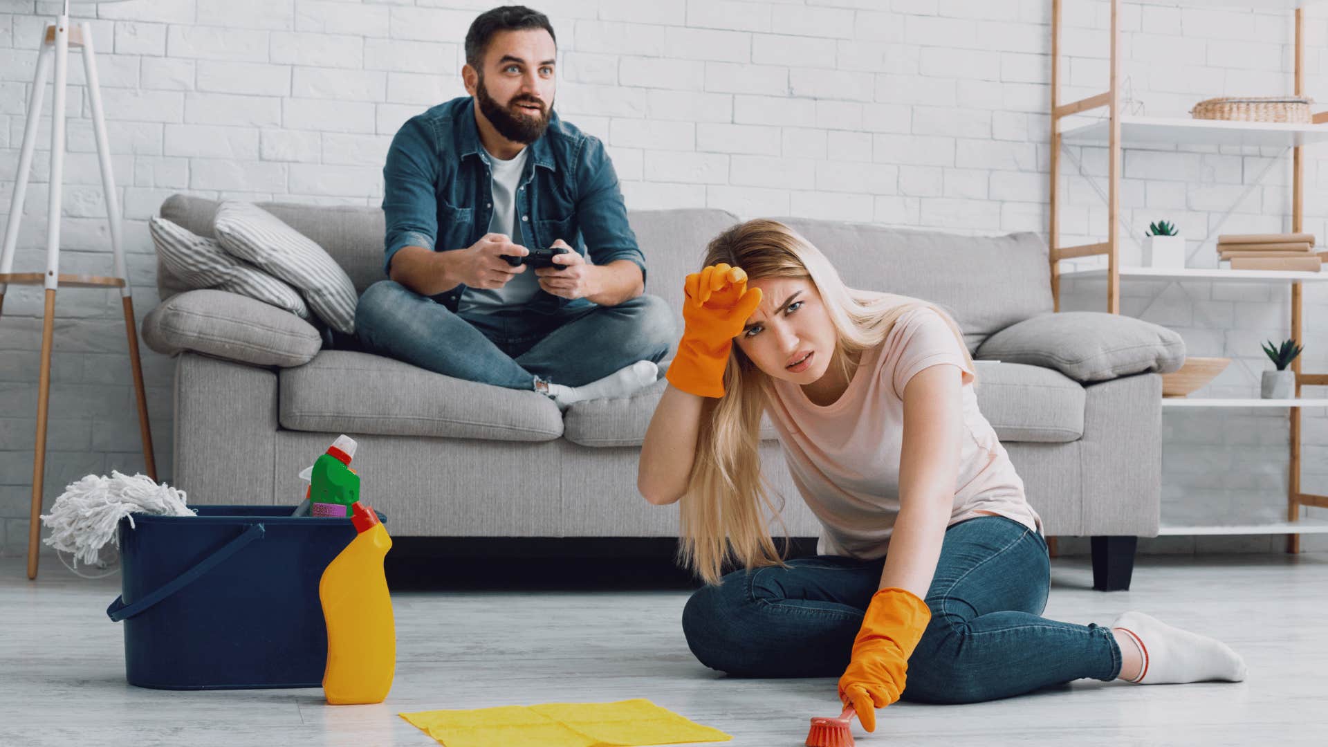 woman cleaning while husband plays video games