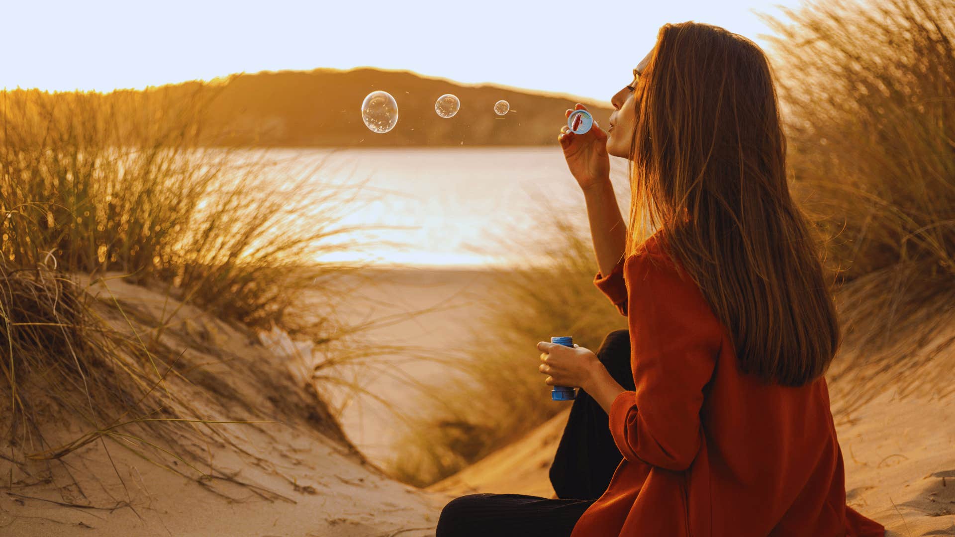 woman blowing bubbles on the beach