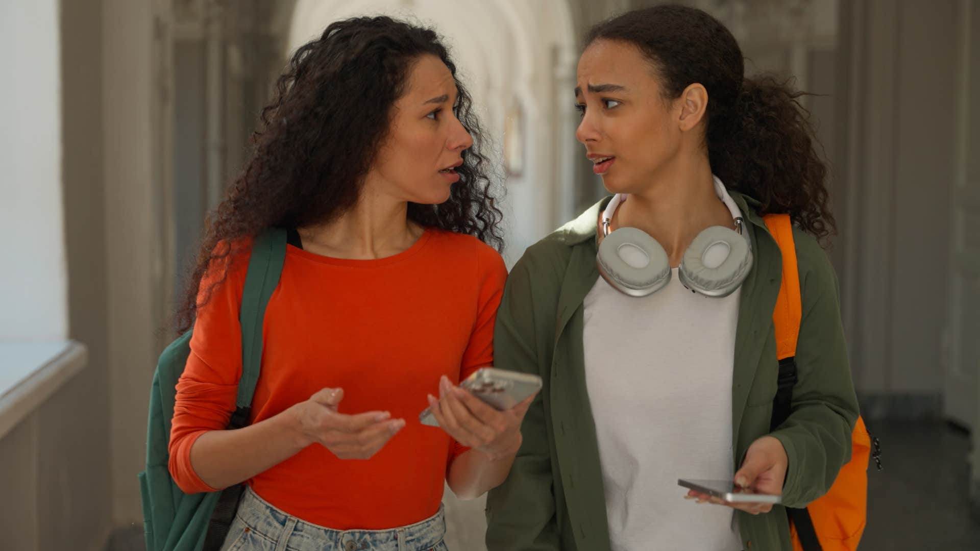 Two women walking together and having a serious conversation.