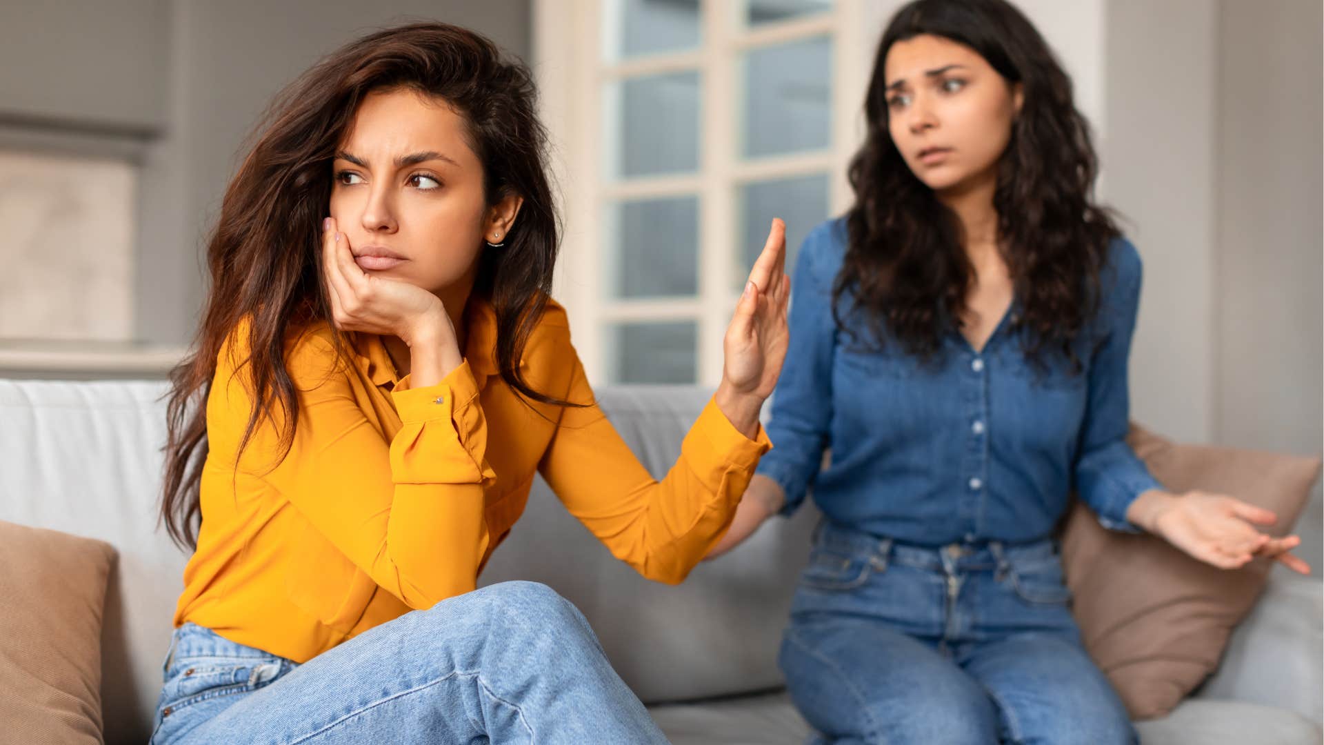 Woman turned away and holding her hand up to a friend.