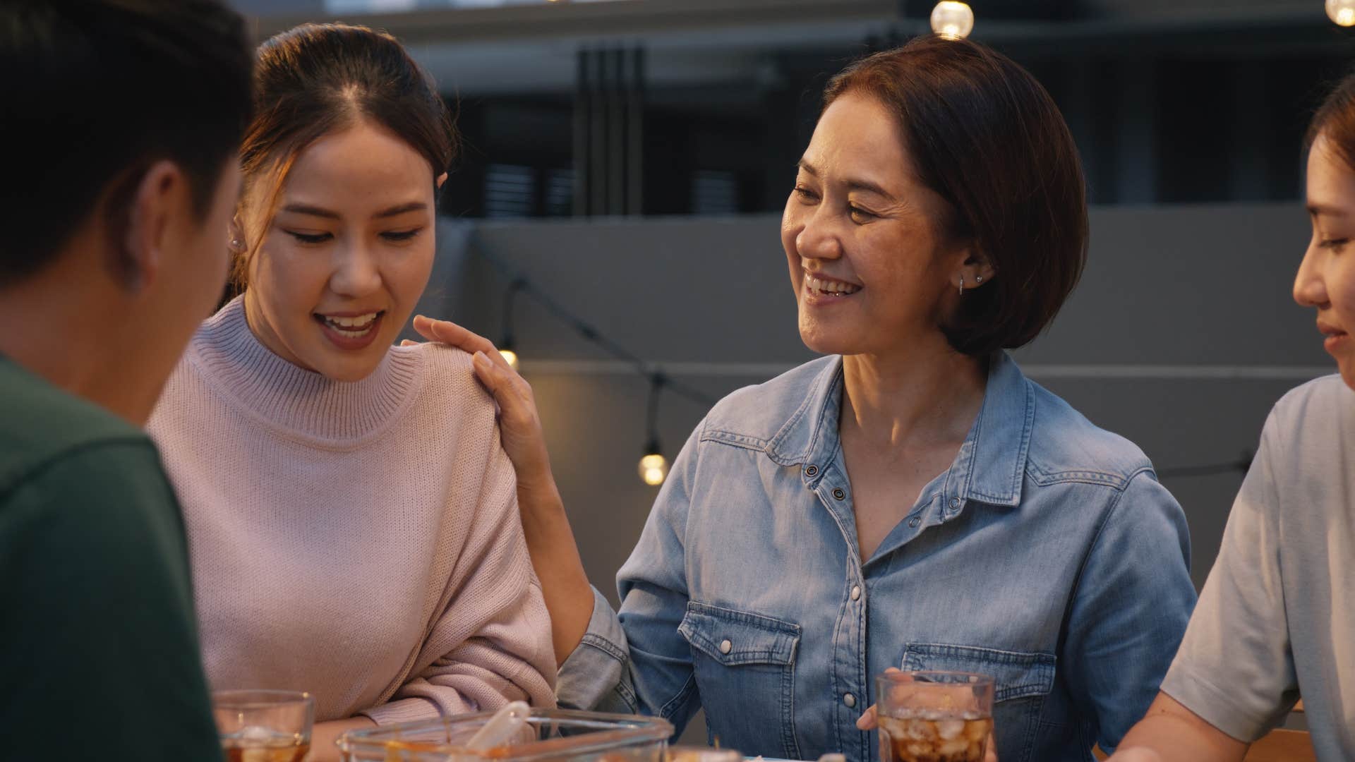 woman touching her adult daughter's shoulder