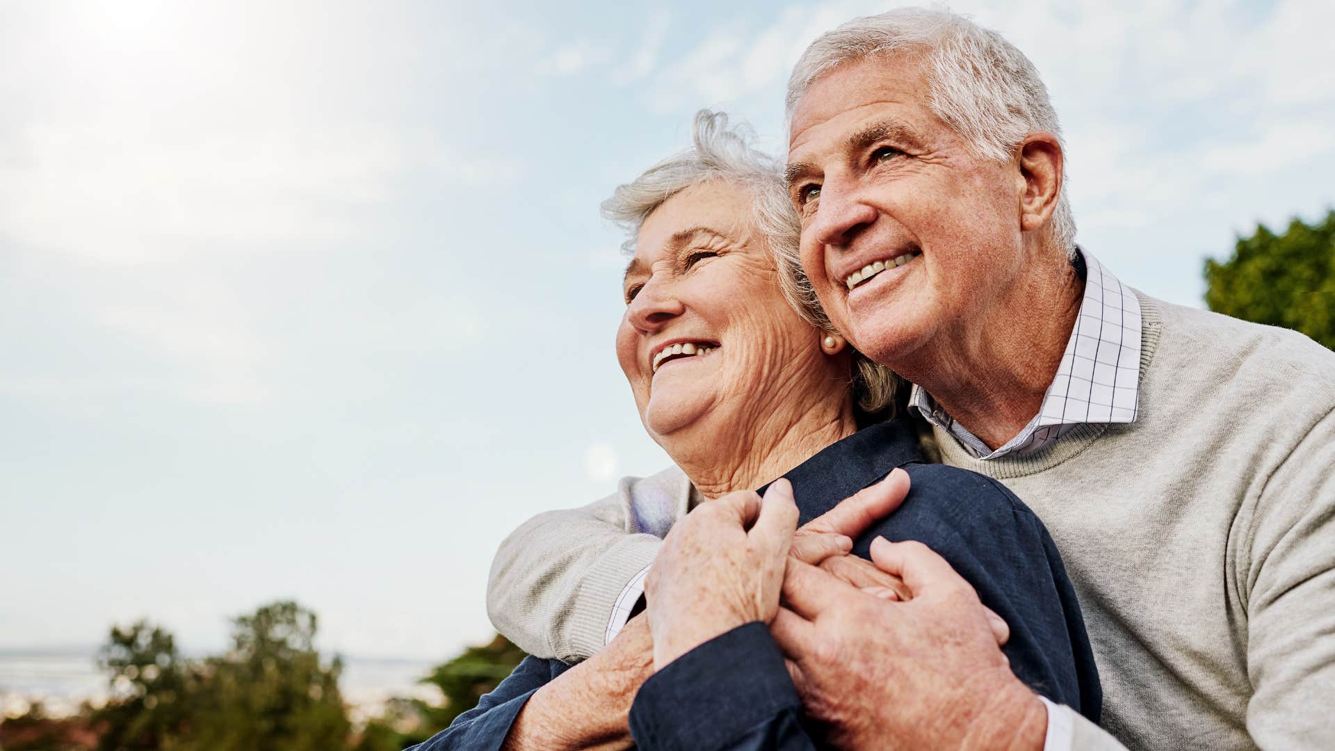 Older couple smiling and hugging each other.