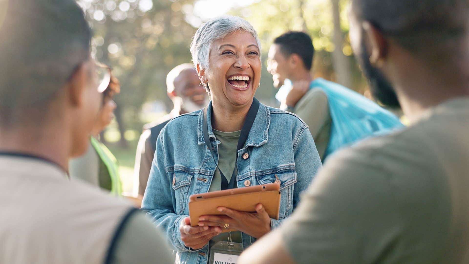 Woman smiling and laughing with two men.