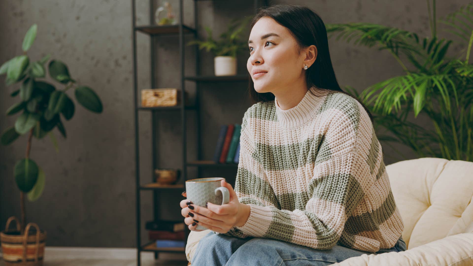 Woman smiling and sitting alone at home.