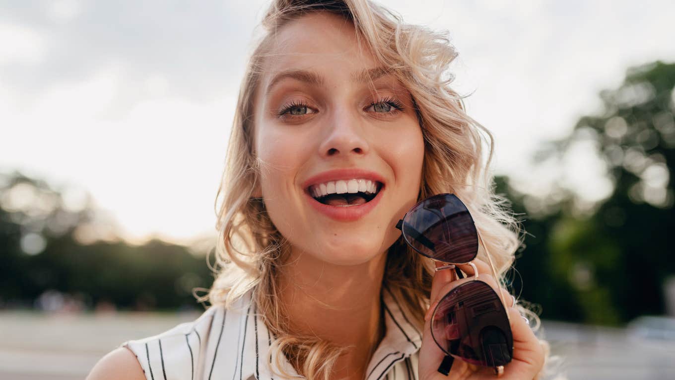 close-up portrait of young stylish blonde woman in city street