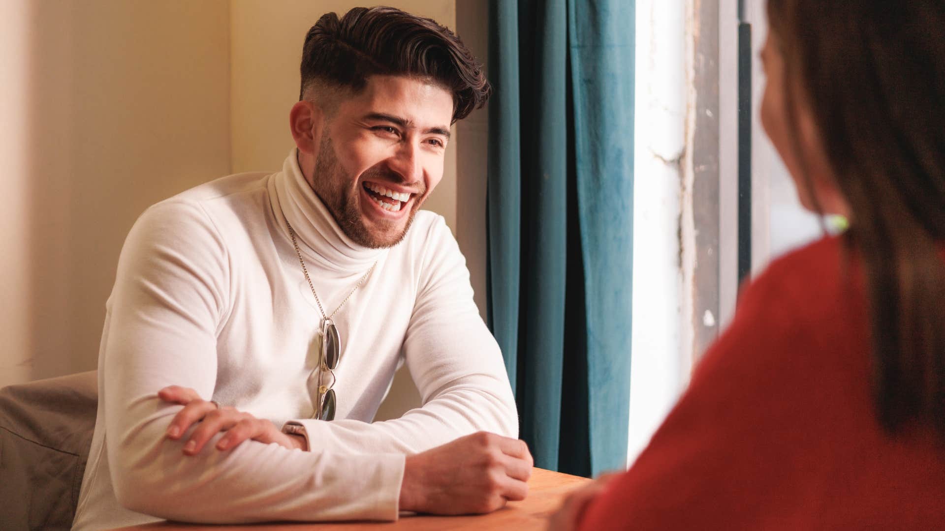 Man smiling at a woman across the table.