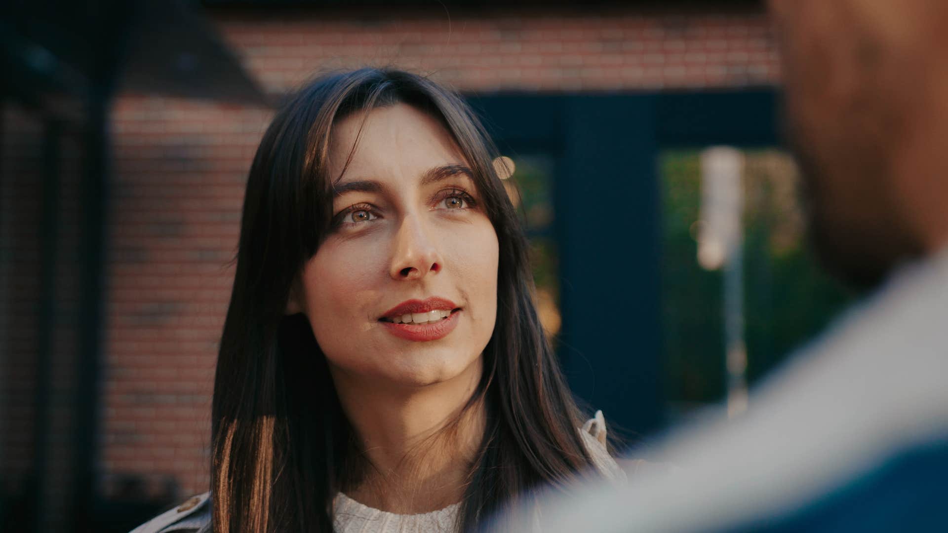 Woman smiling and talking to a man.